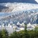 Craggy ice of the Mendenhall Glacier fills a valley before terminating into a lake
